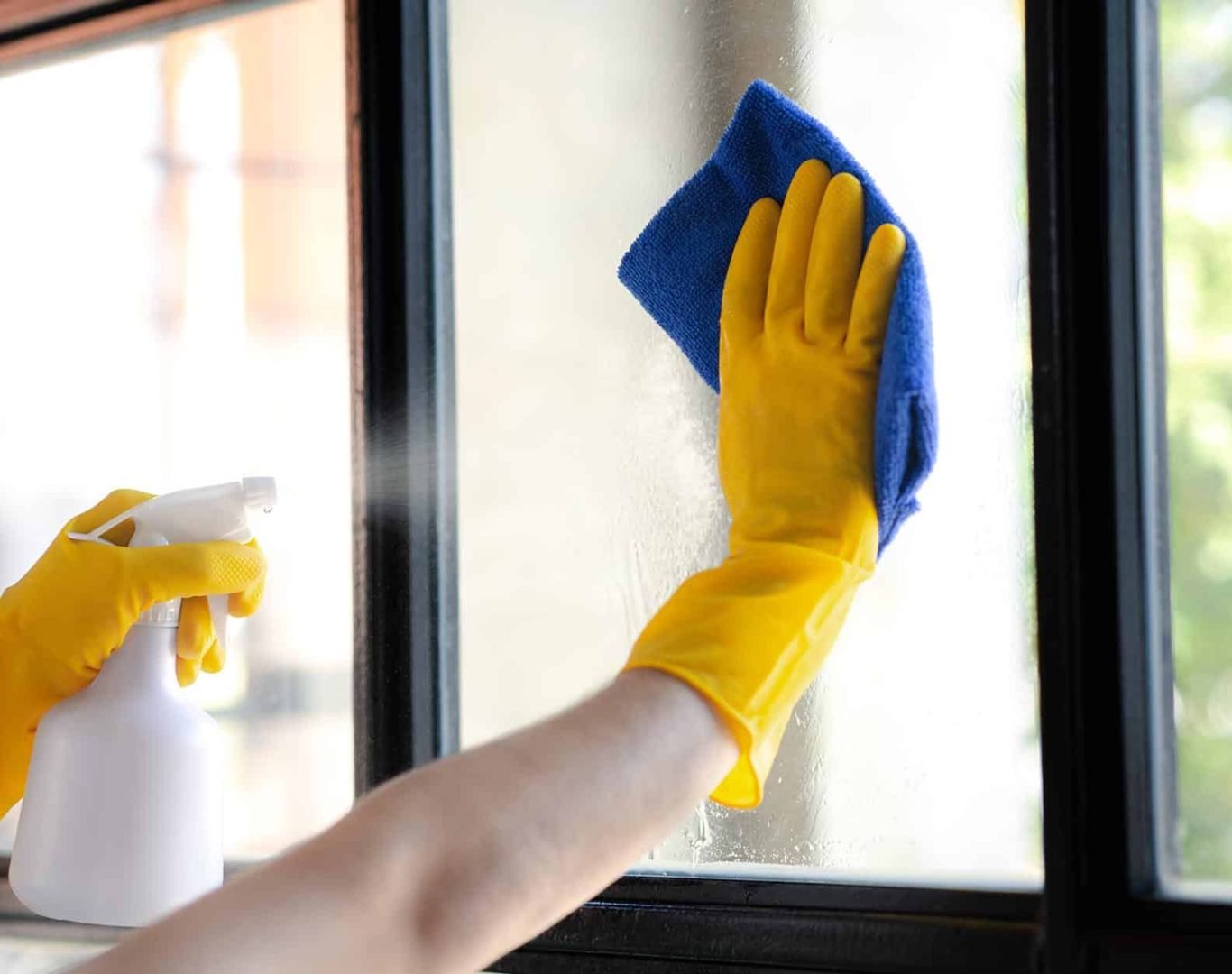 Close-up-of-a-person-in-yellow-gloves-cleaning-a-window